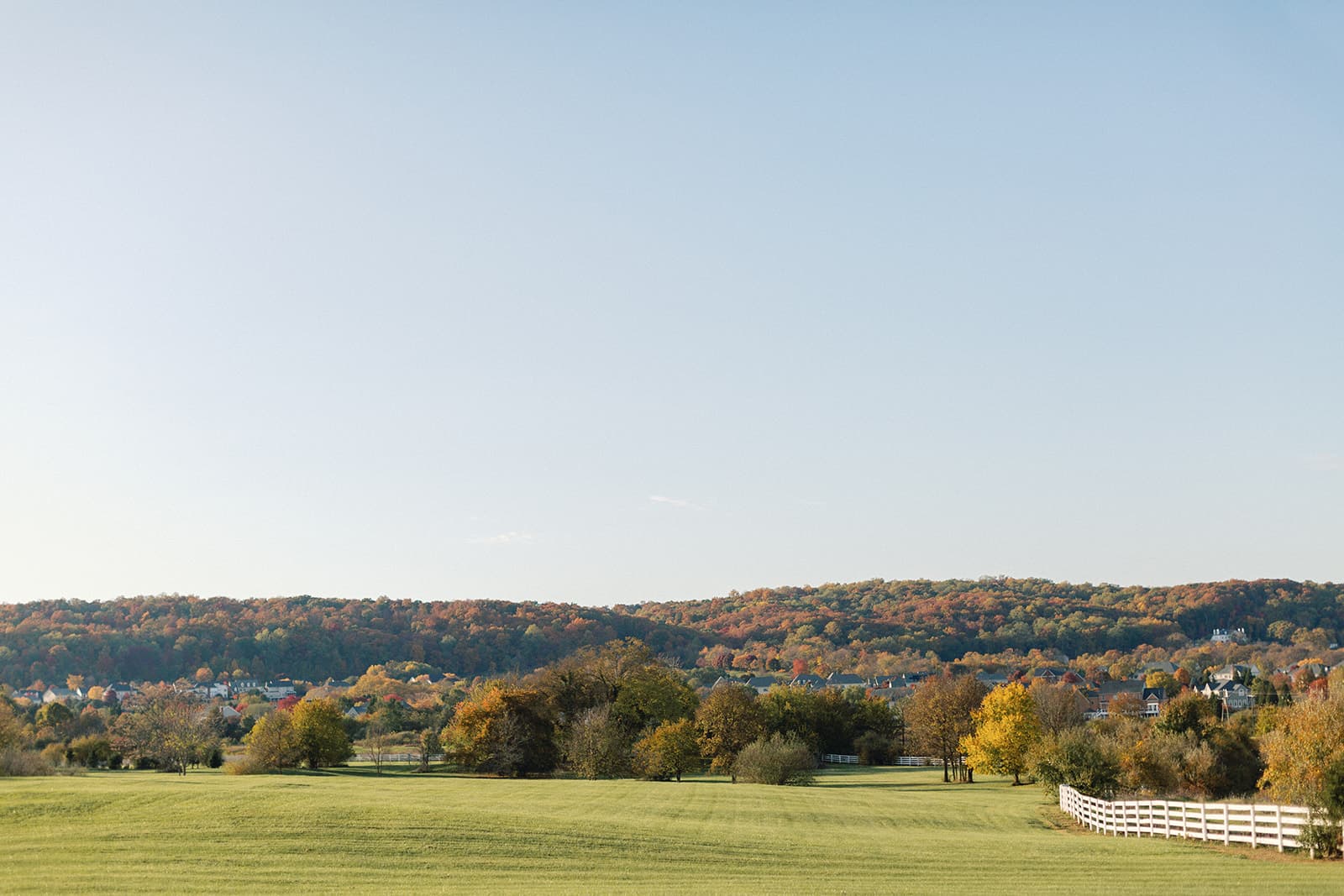 Rolling pasture at golden hour ringed by autumn hillsides
